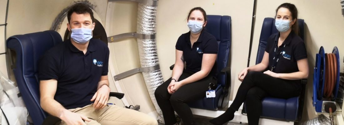 Three doctors sat inside a hyperbaric chamber