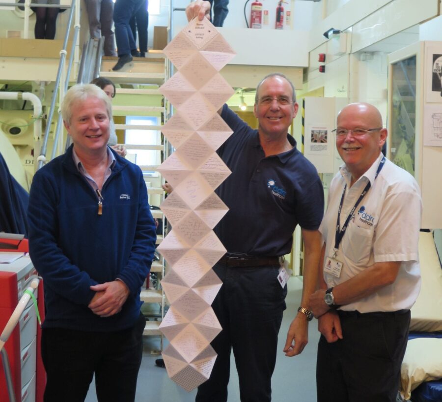 Lawry shows off his leaving card flanked by CEO Dr Gary Smerdon and Operations Director Pete Atkey.